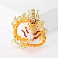 Detailed close-up of cartoon dragon brooch with orange enamel and a white pearl bead - Gold Yellow