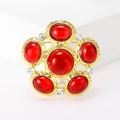 Macro detail of red gemstone flower brooch with textured gold plating and crystals - Red Resin With White Rhinestone