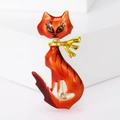 Dettaglio di una spilla a gatto in smalto arancione con base in lega dorata e spillina - Rosso