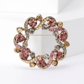 Macro detail van vintage ronde krans broche met gekleurde strass steentjes op bronzen basis - Vintage Roze Paars