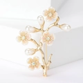 Detailansicht der goldenen Pfirsichzweig-Brosche mit Perlen und rosa Blütenblättern - Gold