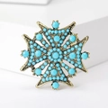 Detailansicht der Vintage-Sternbrosche mit türkisfarbenen Perlen und Bronzefinish - Blau