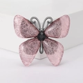 Detail der rosa Schmetterlingsbrosche mit Faserstruktur und schwarzem Metallkörper - Rosa