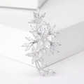 Macro shot of silver plum blossom brooch with inlaid marquise and round cubic zirconia - Silver