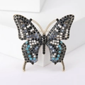 Detailopname van kleurrijke strassteentjes op een vintage vlinderbroche met goudkleurige legering - Inktblauw Veelkleurig