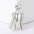 Detalle del broche dental de metal plateado pulido con piedra de circón brillante - Plateado