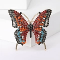 Macro-opname van vintage vlinderbroche met kleurrijke strassteentjes op goudlegering - Helderrood Veelkleurig