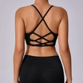 Detail der überkreuzten Rückenträger des schwarzen Yoga-BHs mit geometrischem Design - Schwarz