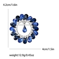 Runde Brosche in Silberoptik mit blauen Strasssteinen und Tropfenanhänger, 4,2 cm groß - Blau