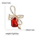 Elegant crystal bow brooch featuring a large red rectangular gemstone with gold accents - Red