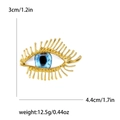 Golden Evil Eye brooch with long eyelashes and dimensions shown on white background - Gold
