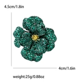 Exquisite camellia brooch with green cubic zirconia and gold-tone center in black finish - Green