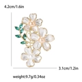Spilla dorata elegante con tre fiori di camelia bianchi e foglie verdi con misure - Bianco