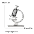 Vista de detalles del broche de microscopio plateado con strass, mide 3,1 cm por 2,9 cm - Plateado