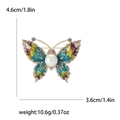 Macro-opname van kleurrijke vlinderbroche met emaille, parel en glinsterende strass-steentjes - Groen