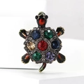 Dettaglio della spilla tartaruga vintage con pietra rossa e cristalli multicolori su base bianca - Colore 4517-bl Dimensioni: 35*27*15 Cm Peso: 8 G