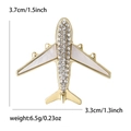 Minimalist gold alloy airplane brooch with rhinestones and white enamel details - Gold