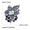 Dettaglio spilla vintage in lega con strass sfumati e perla centrale per abiti donna - Blu