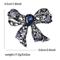 Detail view of vintage hollow bow brooch with blue rhinestones and dimensions shown - Blue