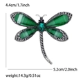 Detailed view of dragonfly brooch with emerald green resin wings and black rhinestones - Green