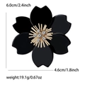 Elegant black acrylic flower brooch with gold stamen and rhinestones measuring 6.0cm by 4.6cm - Black