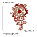 Elegant gold flower brooch with red rhinestones and butterfly detail, 10.6cm in size - Red