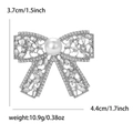 Vintage zilveren strikbroche met strass en witte parel op een witte achtergrond - Zilver