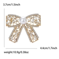 Elegante gouden strikbroche met fonkelende steentjes en een witte parel voor dames - Goud