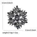 Detail showing vintage snowflake brooch dimensions of 6.5cm by 5.5cm on white background - Black