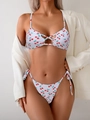 Close-up of cherry print bikini with cut-out details and side-tie bottoms on model - S / Small Cherry