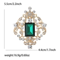 Macro detail of vintage brooch showing dimensions 5.5cm by 4.4cm with emerald green stone - Green