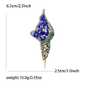 Detailoverzicht van de schelpbroche met maten 6,3cm x 2,5cm en blauwe stenen - Goud