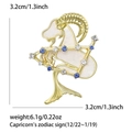Dettaglio della spilla Capricorno con smalto bianco, strass blu e dimensioni esatte - Capricorno-Oro / Articolo:5253-GD