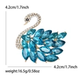 Elegant gold swan brooch featuring sparkling white diamonds and dark blue marquise crystals - Blue
