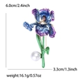 Dettaglio della spilla a iris con petali smaltati, gemma marrone e goccia di perla bianca - Viola