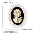 Detail van een vintage portretbroche met goudkleurig reliëf, zwart email en parels - Goud & Zwart