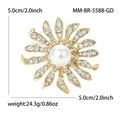 Dettaglio di una spilla a forma di girasole con strass, perla centrale e finitura in oro - Oro