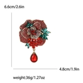 Elegant rose brooch with red crystals and pear-shaped pendant on white background - Red