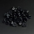 Macro view of black rubber pin backs for badges and brooches on dark textured surface - Black