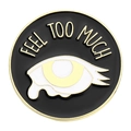 Round black enamel pin with Feel Too Much text and minimalist crying eye graphic - FEEL TOO MUCH (XZ6862)