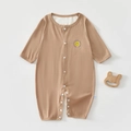 Close-up of brown baby romper with smiley face print and wooden bear teething toy - Coffee / Size 66