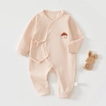Détail d'une grenouillère bébé en coton rose avec liens et broderie écusson maison - 52cm / Rose racine de lotus