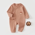 Détail d'un body bébé en coton côtelé rose brique avec broderie maison et nœuds latéraux - 52cm / Châtain