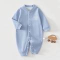 Détail d'une grenouillère bébé en cachemire et soie bleu clair avec boutons et ours - Taille 73 / Bleu