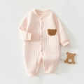 Détail d'un body rose pour bébé avec écusson ourson en peluche et tissu côtelé doux - Rose
