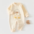 Detailed close-up of cream baby romper featuring herringbone texture and cartoon duck - Rice Glutinous Little Duck