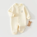 Detail eines gesteppten Baby-Einteilers mit Druckknöpfen und gelbem Smiley-Stickerei - Größe 66 / Beige