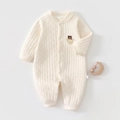 Detailed quilted texture of cream newborn romper with bear pattern and wooden rattle - Bear Head Print