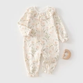 Detail of floral baby romper with ruffled collar and wooden moon rattle on gray backdrop - 59 / Floral Rabbit