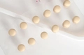 Detail view of cream magnetic scarf clips arranged neatly on a white display board - Beige Spherical Magnetic Clip (XZ4595)